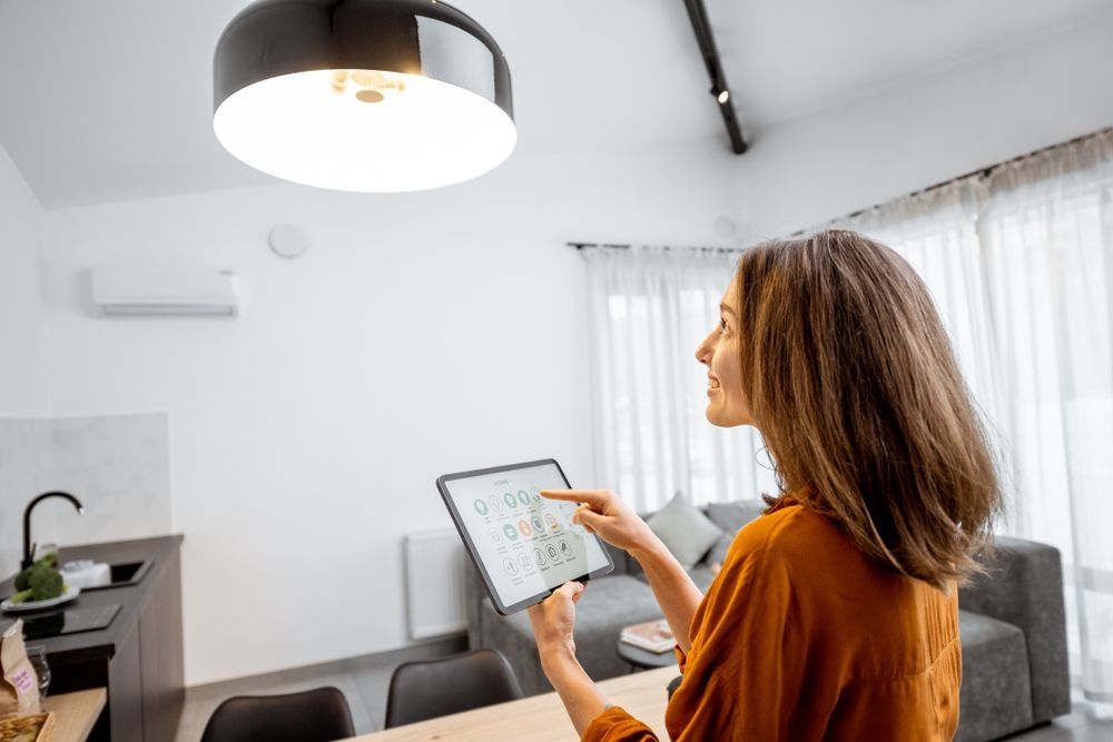A Woman is Using a Tablet in a Living Room — Adept Security In Shellharbour, NSW