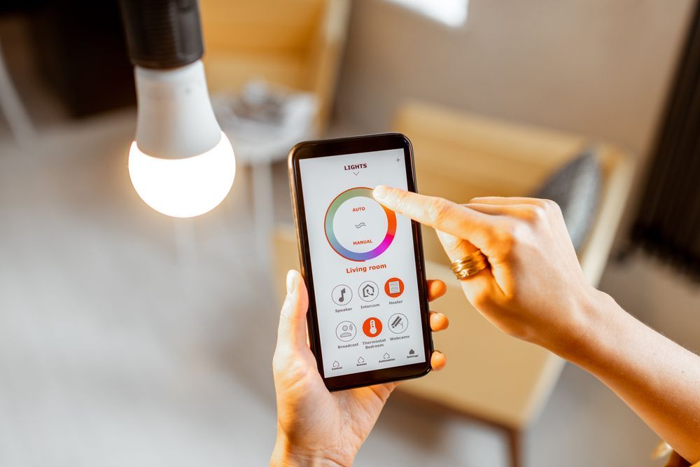 A Person is Using a Smart Phone to Control a Light Bulb — Adept Security In Albion Park, NSW