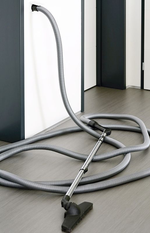 A Vacuum Cleaner With a Hose Attached to It is Sitting on the Floor — Adept Security In Oak Flats, NSW