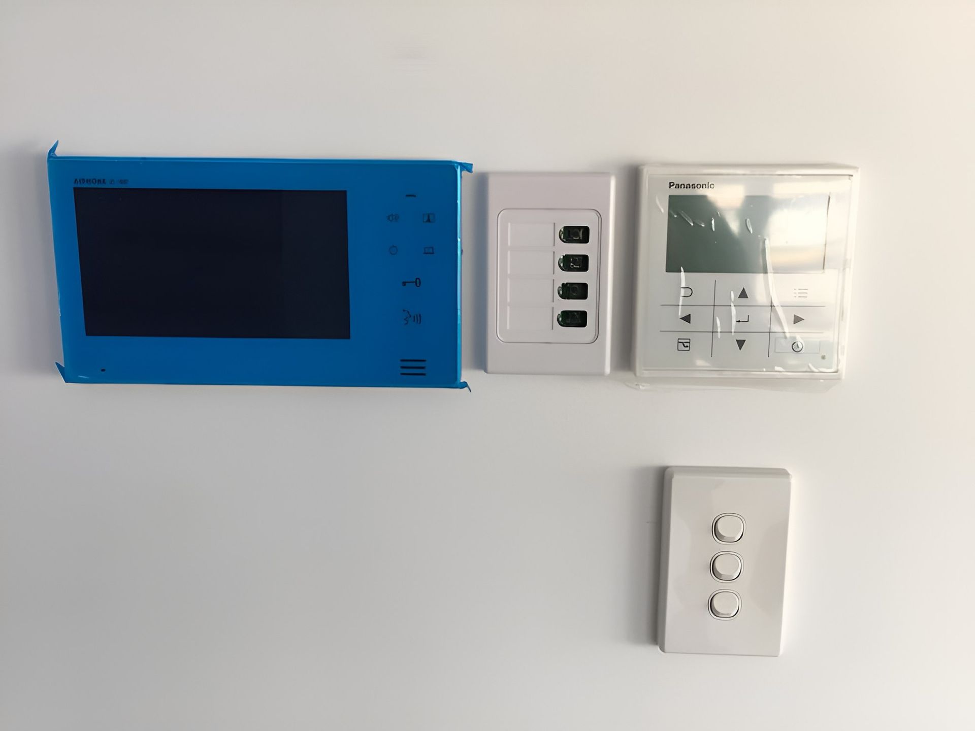 A Blue Monitor and a White Thermostat Are Mounted on a White Wall — Adept Security In Corrimal, NSW