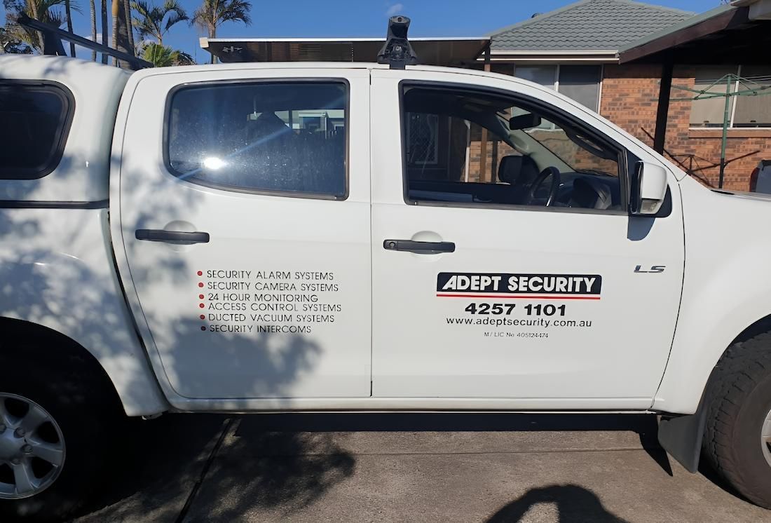 A White Security Truck is Parked in Front of a House — Adept Security In Oak Flats, NSW