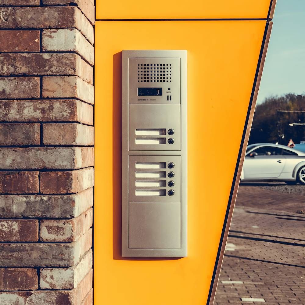 A Brick Wall With a Doorbell on It and a Car Parked in the Background — Adept Security Kiama, NSW