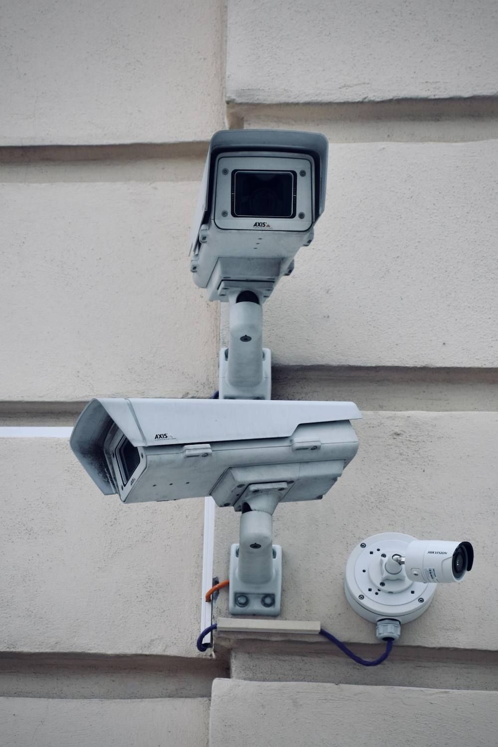 Two Security Cameras Are Mounted on the Side of a Building — Adept Security In Albion Park, NSW