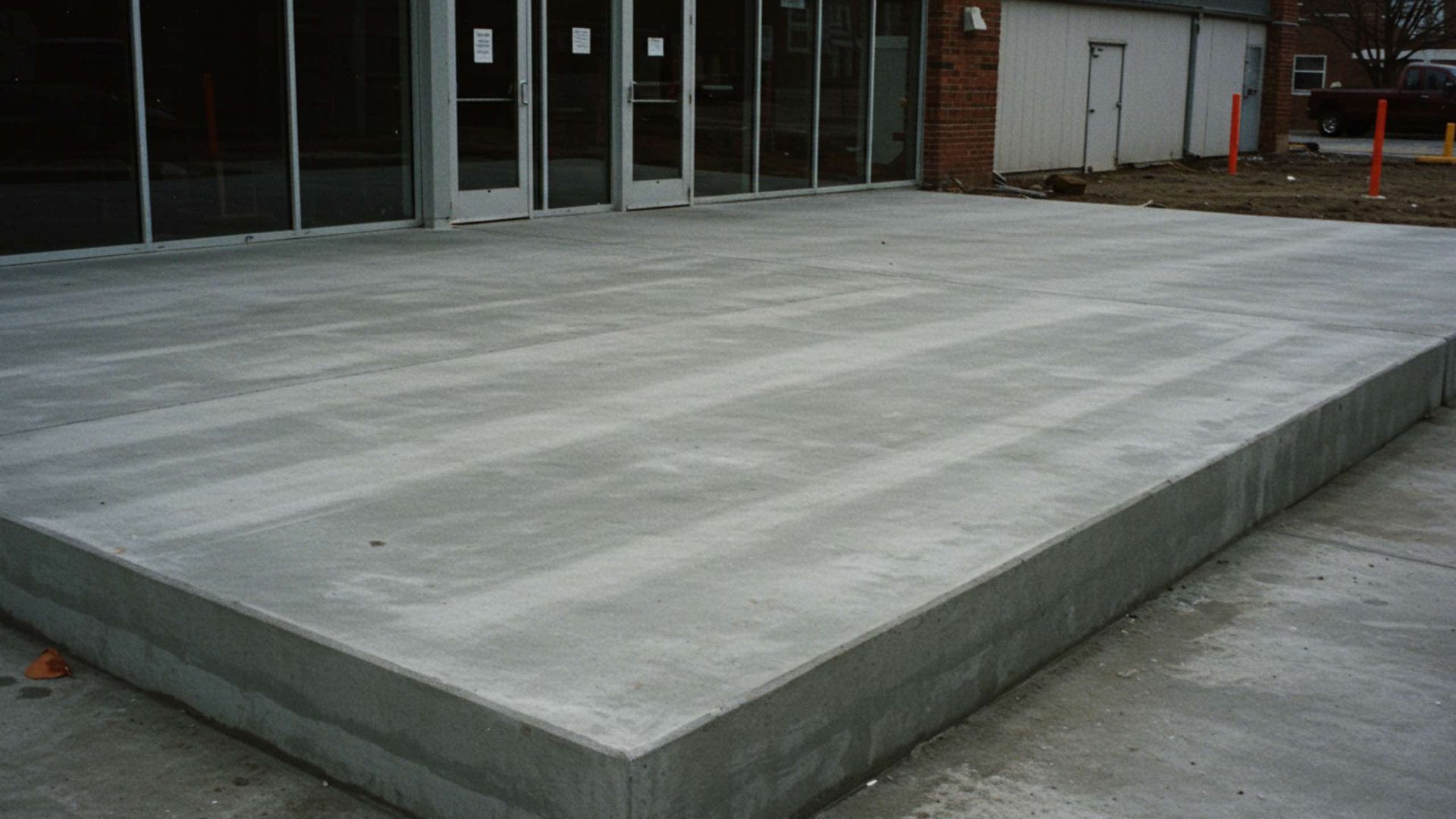 Concrete ramp leading to glass doors of a building.