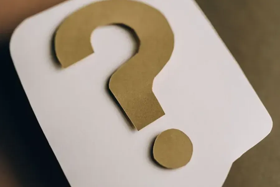 Gold question mark on a white rounded square card with a smaller dot below