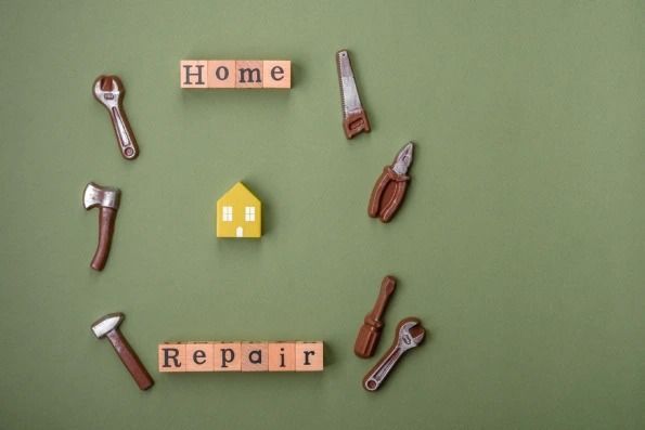 The word home is written on wooden blocks surrounded by tools.