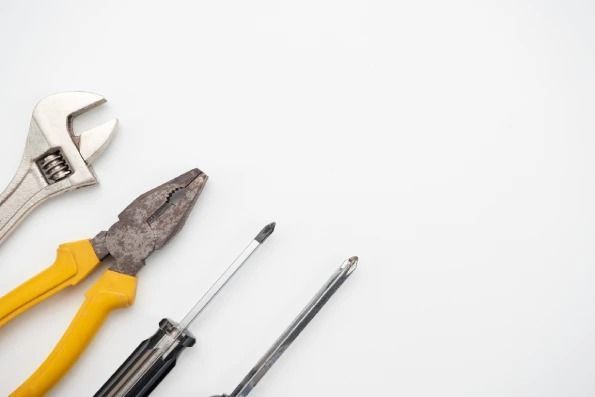 A wrench , pliers , and screwdriver on a white background.
