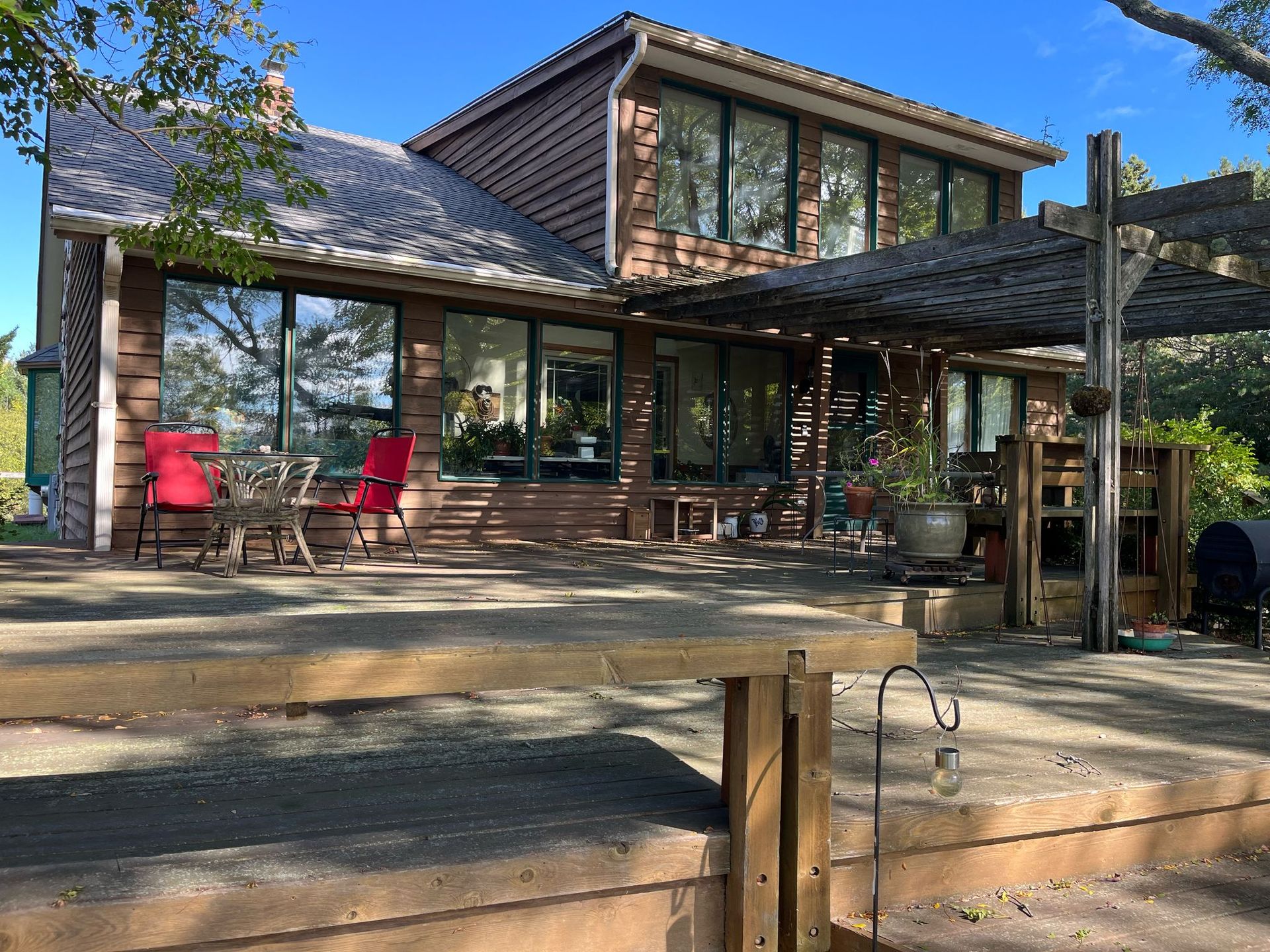 A large brick house with a large deck in front of it.