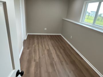 A basement under construction with a concrete floor and wooden walls.