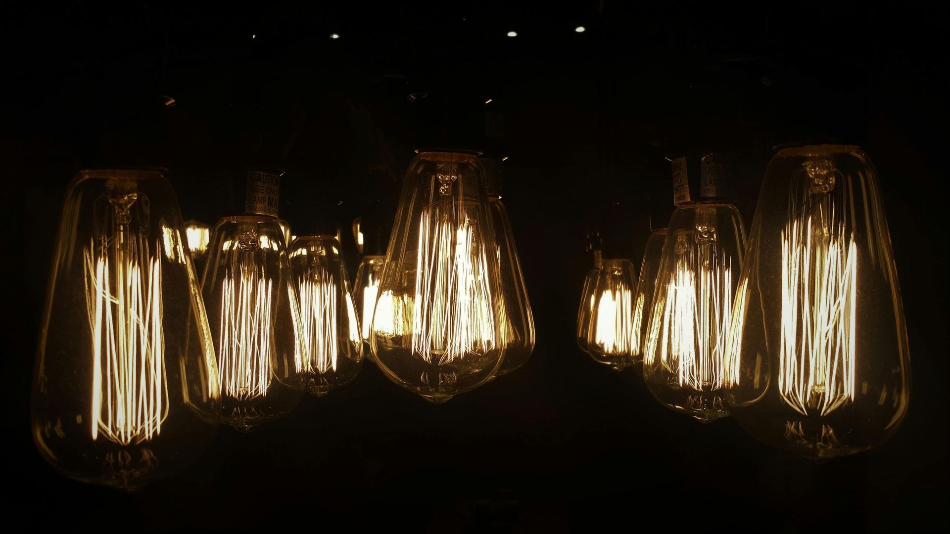 Glowing Edison-style light bulbs against a dark background, showcasing warm light.