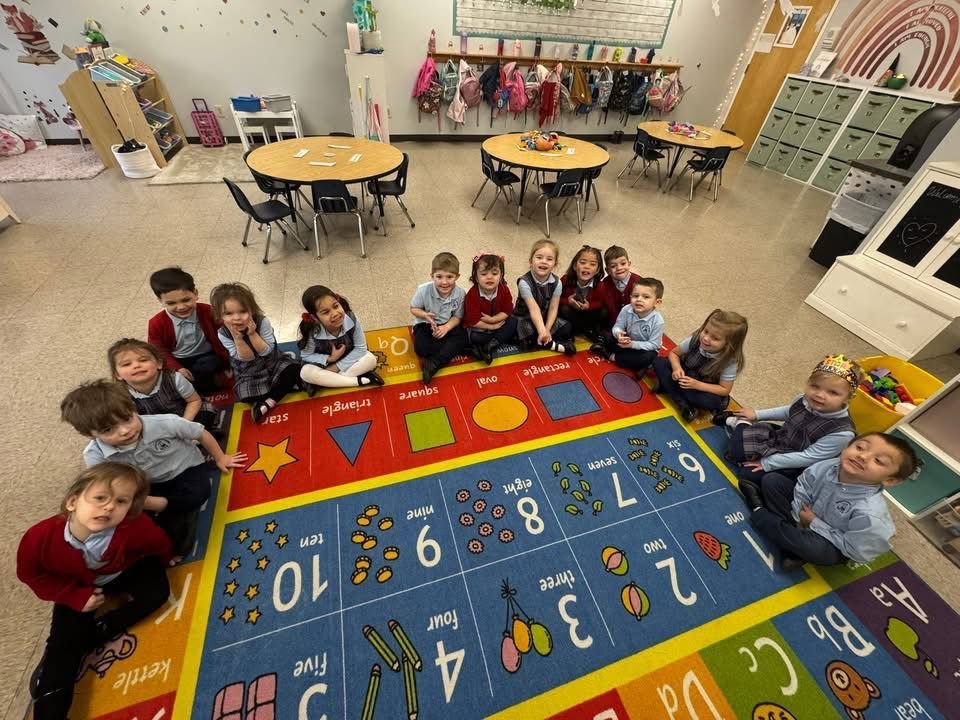Children reading in a cozy purple classroom with inspirational wall posters and books.