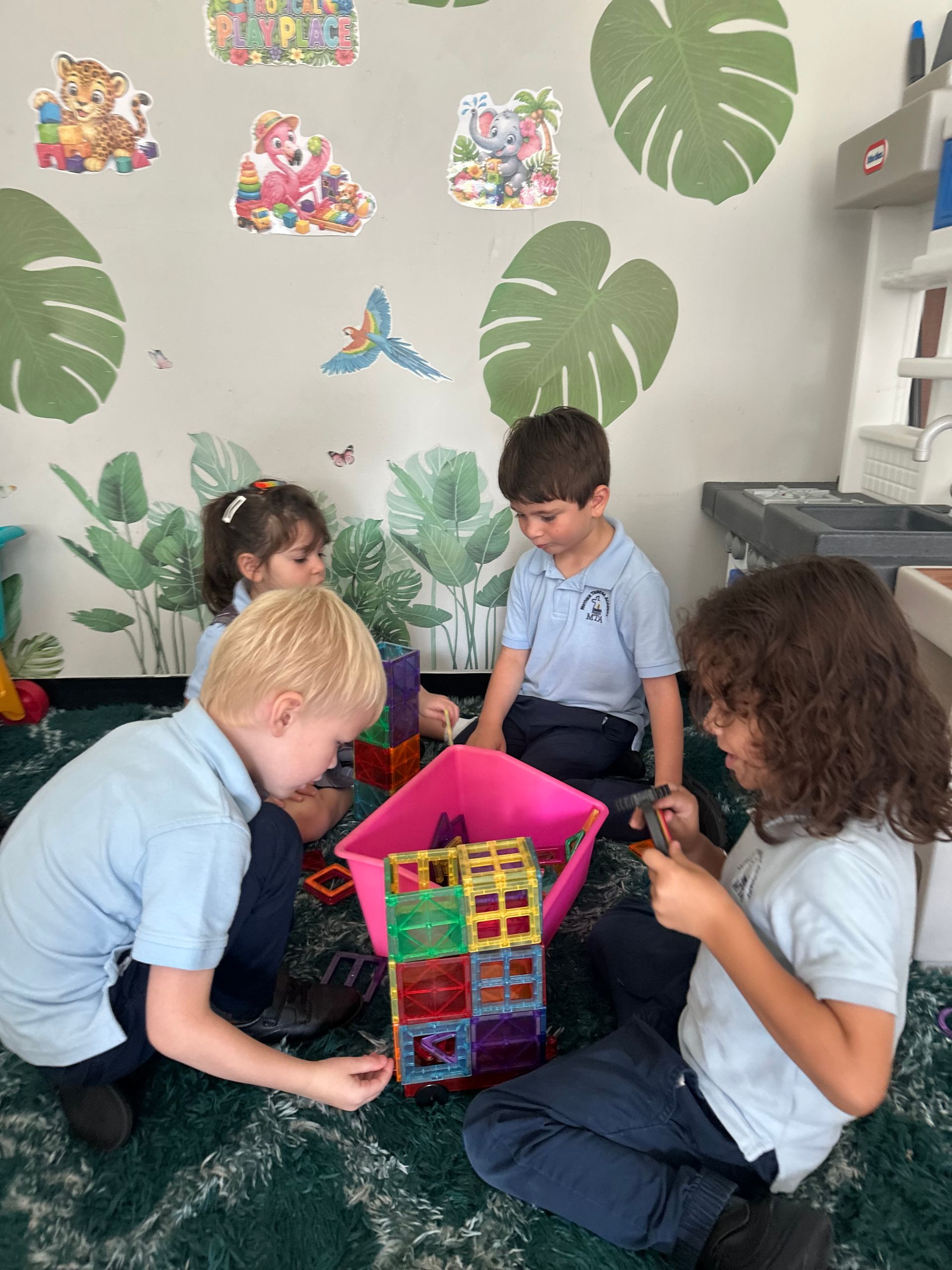 Children reading in a cozy purple classroom with inspirational wall posters and books.