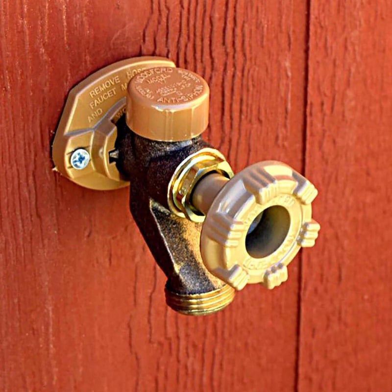 A brass faucet is attached to a red wooden wall