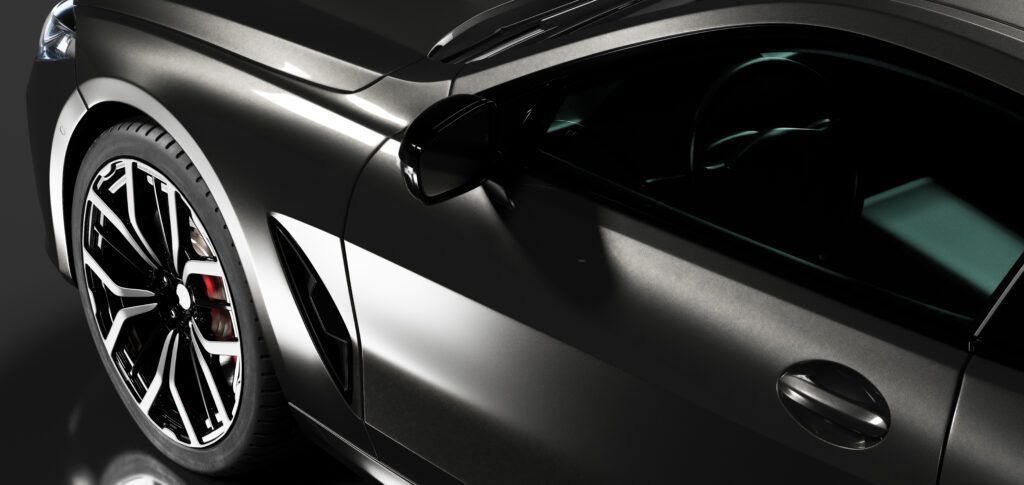 A black sports car is parked on a black surface