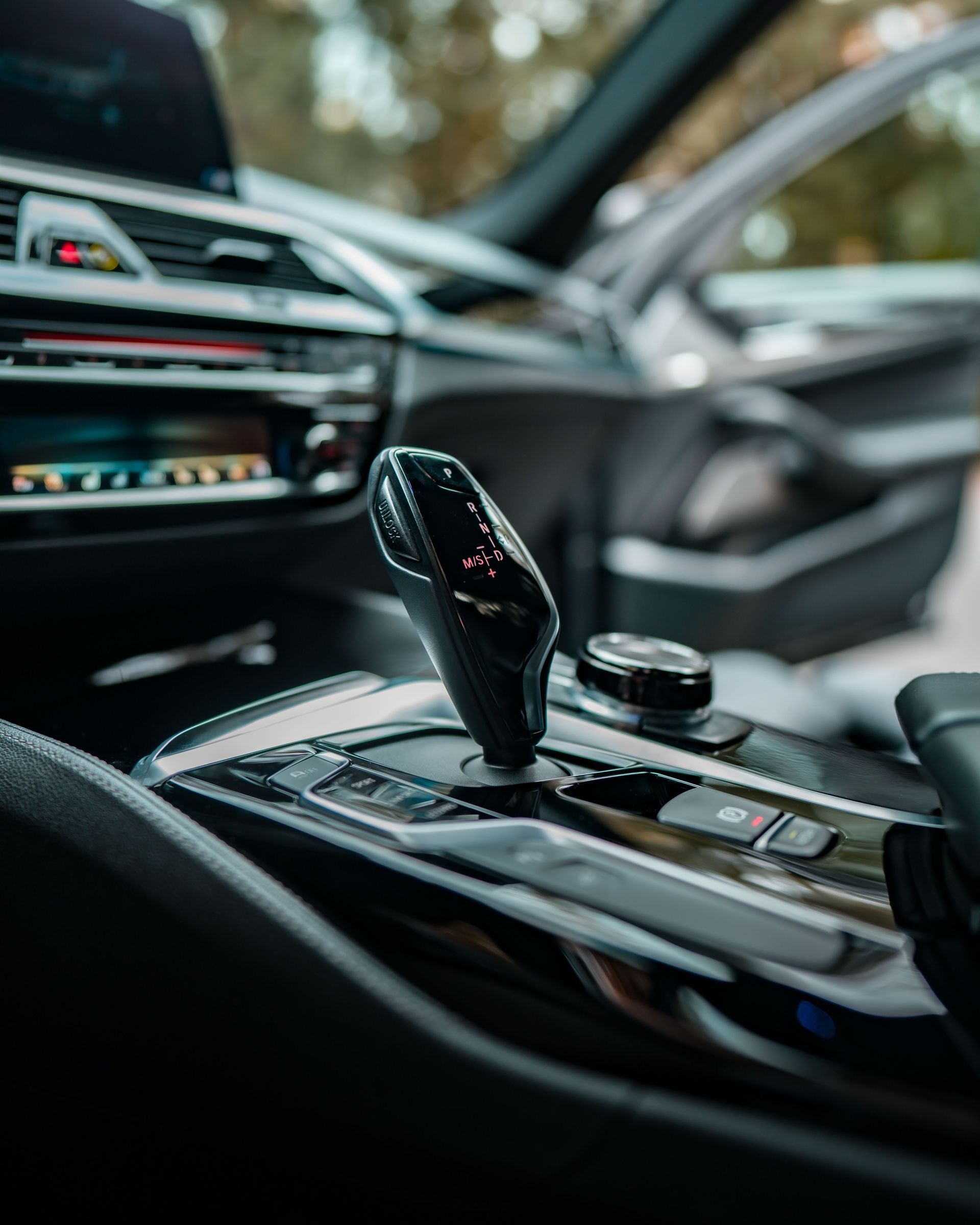 Luxury car center console with gear selector and dashboard controls, seen from the driver’s seat
