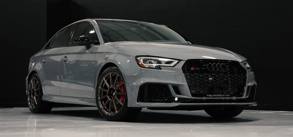 A gray audi rs 3 is parked in a garage.