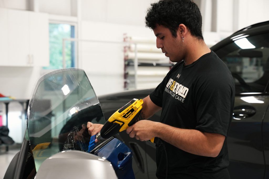 A man is working on a car in a garage.