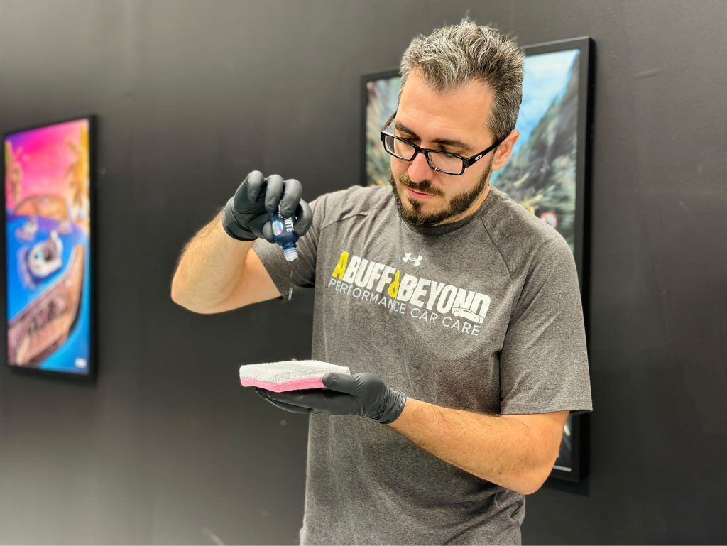 A man wearing glasses and gloves is holding a piece of paper in his hand.