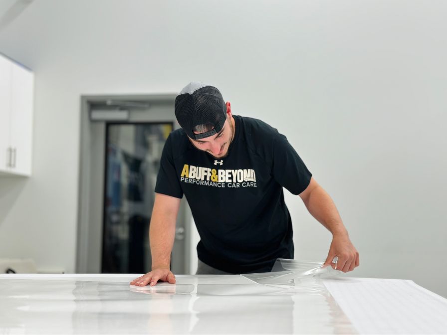 A man in a black shirt is covering a table with plastic.