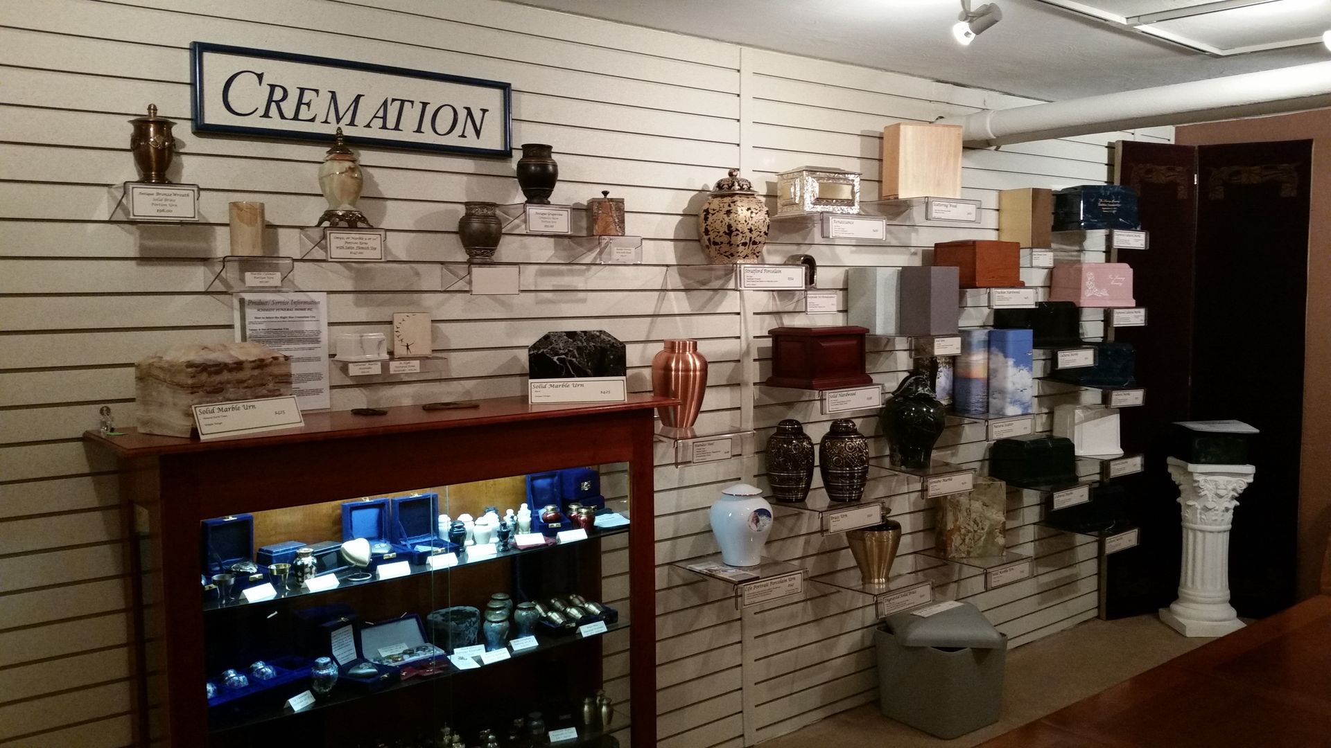 Creamation pet memorial display with shelves, urns, and decorative items in a store interior