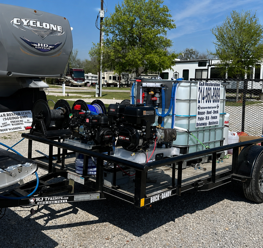 Trailer-mounted equipment with tanks and pumps parked outdoors in a lot under a blue sky