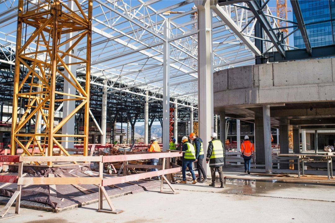 Construction workers inspecting a modern steel building in Colorado USA under bright high-altitude sunlight