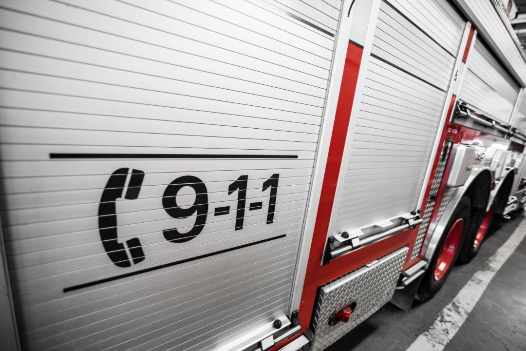 Close-up of a red-and-white fire truck with a 9-1-1 emblem on the side