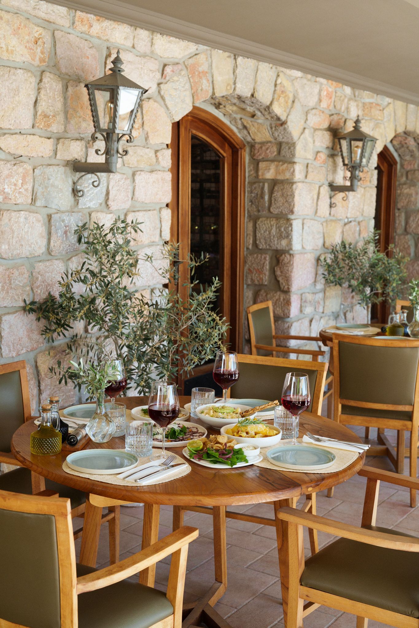 Manzara Boutique Hotel | Outdoor patio dining table with chairs, lanterns, and plates of food in a cozy restaurant setting