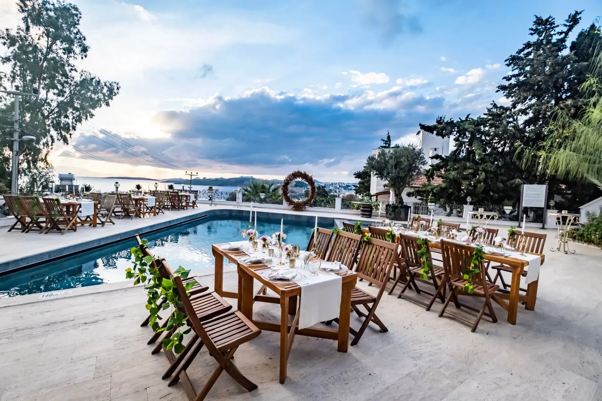 Manzara Boutique Hotel | Poolside dining tables overlooking the ocean at sunset