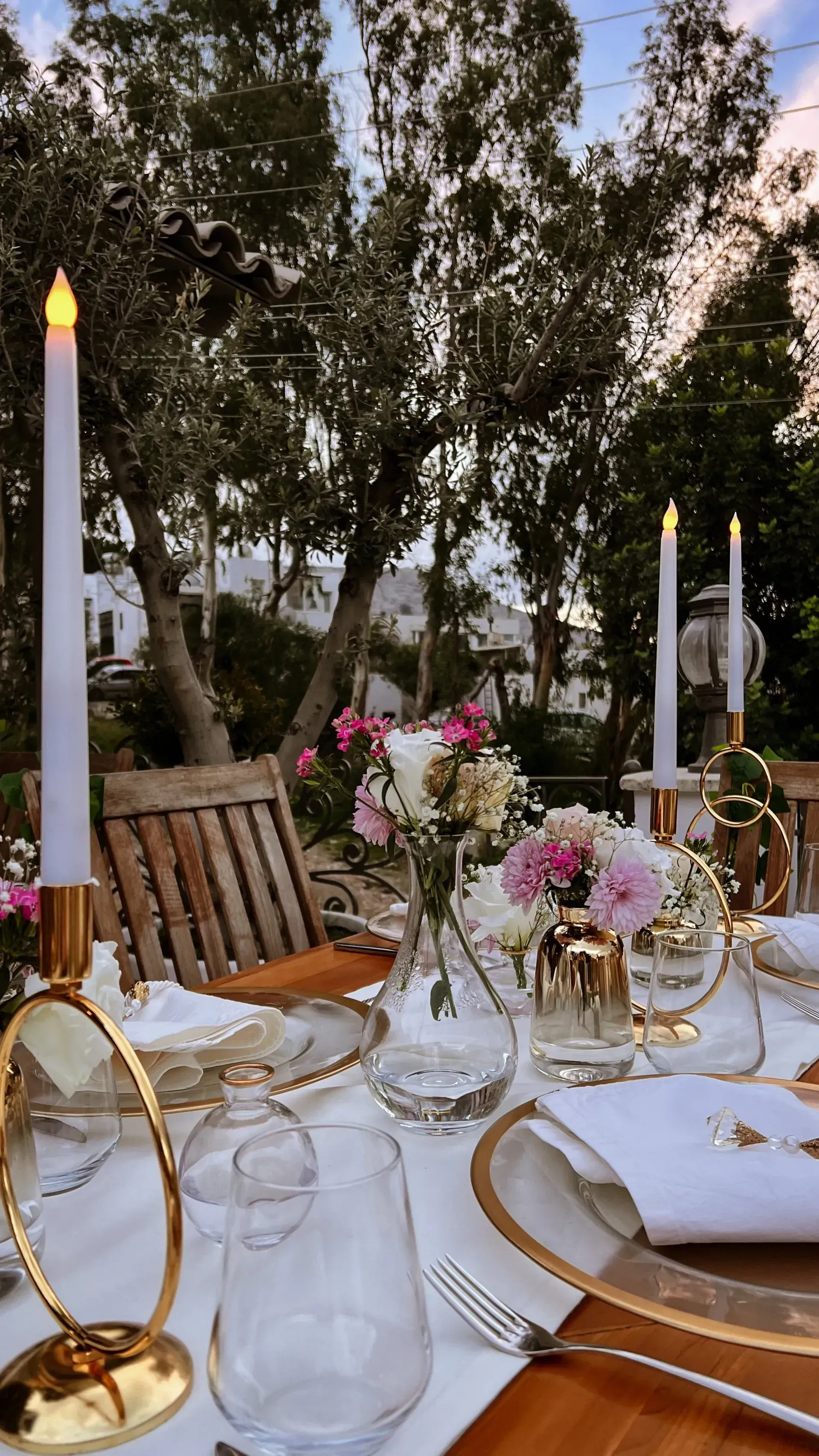 Manzara Boutique Hotel | Elegant outdoor dinner table with white and gold place settings, and lit candles in a garden