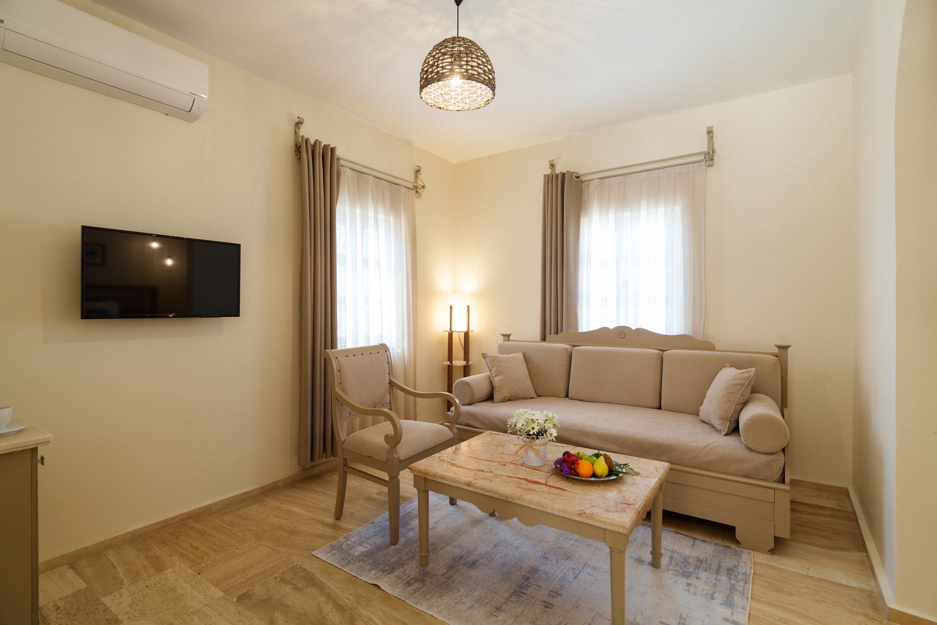 Manzara Boutique Hotel |Cozy beige living room with sofa, armchair, coffee table, and two windows with curtains