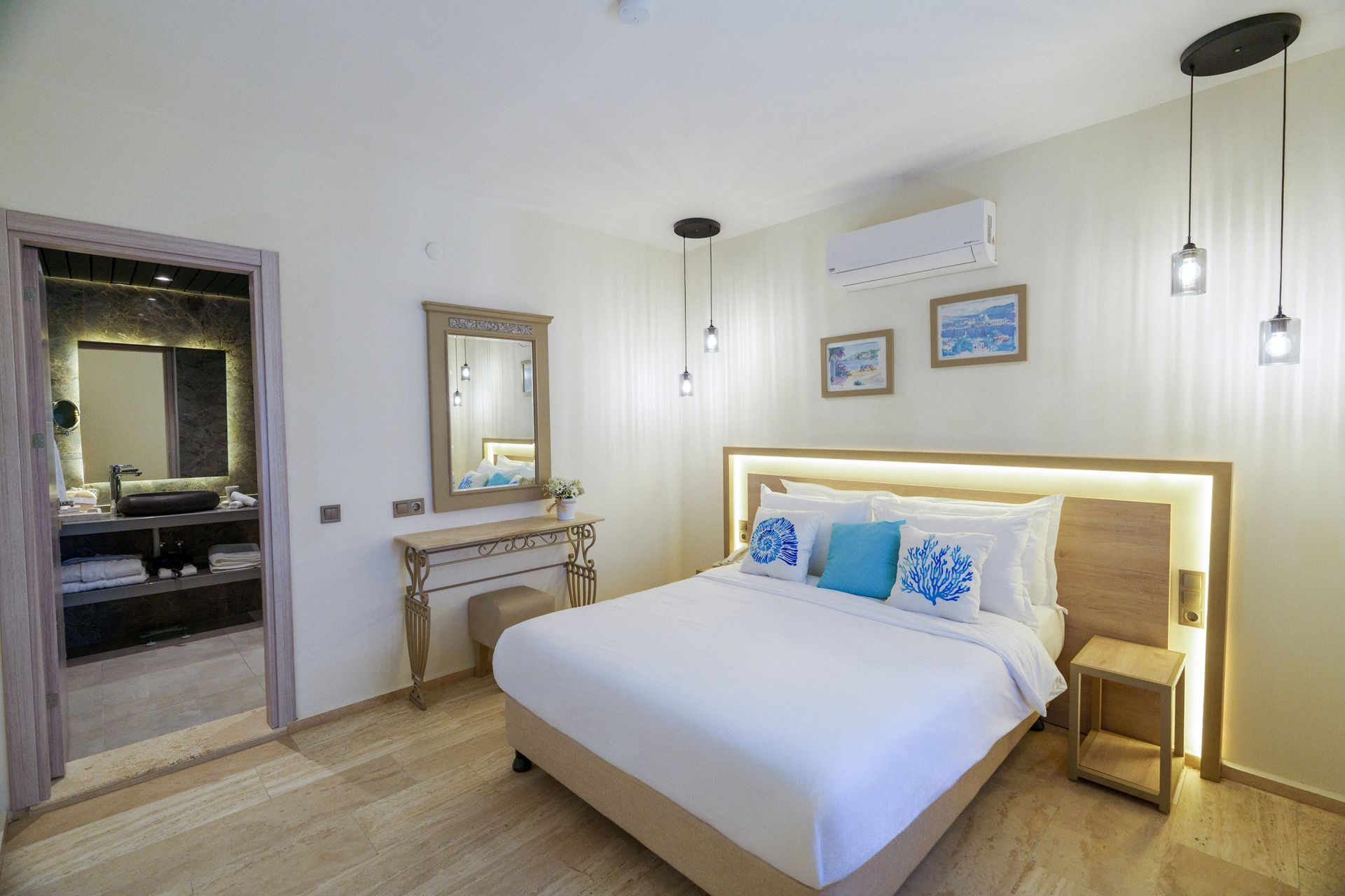 Modern bedroom with king bed, white walls, blue accents, mirror, and hanging pendant lights
