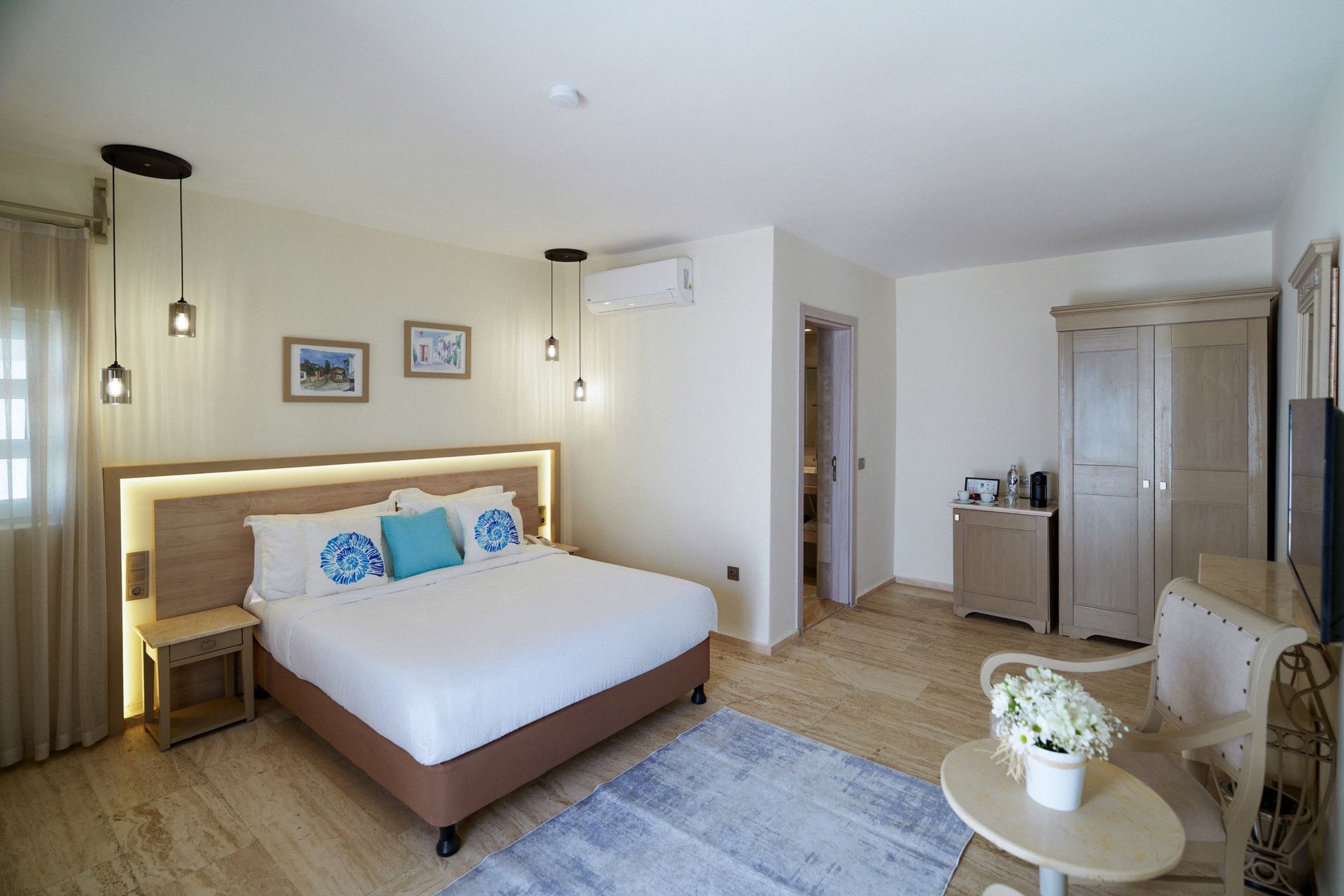 Manzara Luxury Boutique Hotel, Bright modern bedroom with a large bed, hanging lights, desk, wardrobe, and seating area