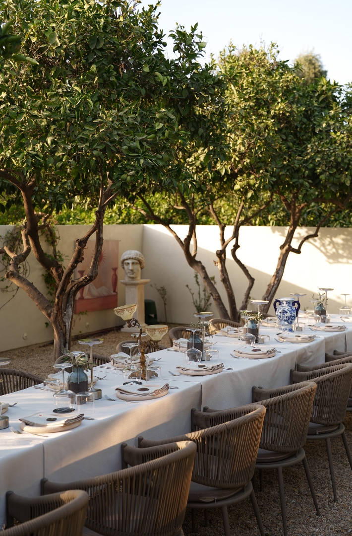 Manzara Boutique Hotel |  Outdoor dining table set under trees in a sunny courtyard