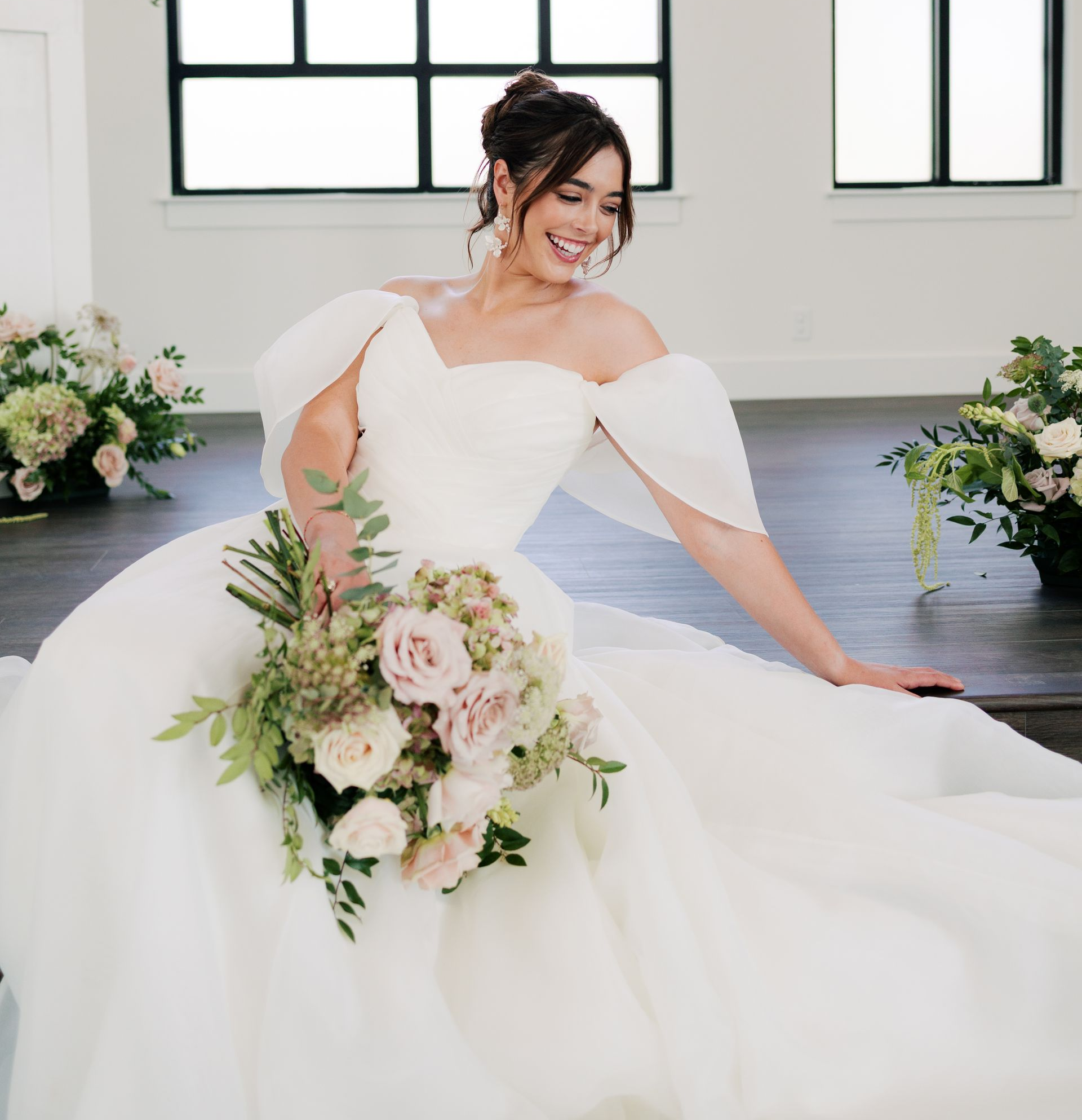 A woman in a wedding dress is standing in front of a large mirror.