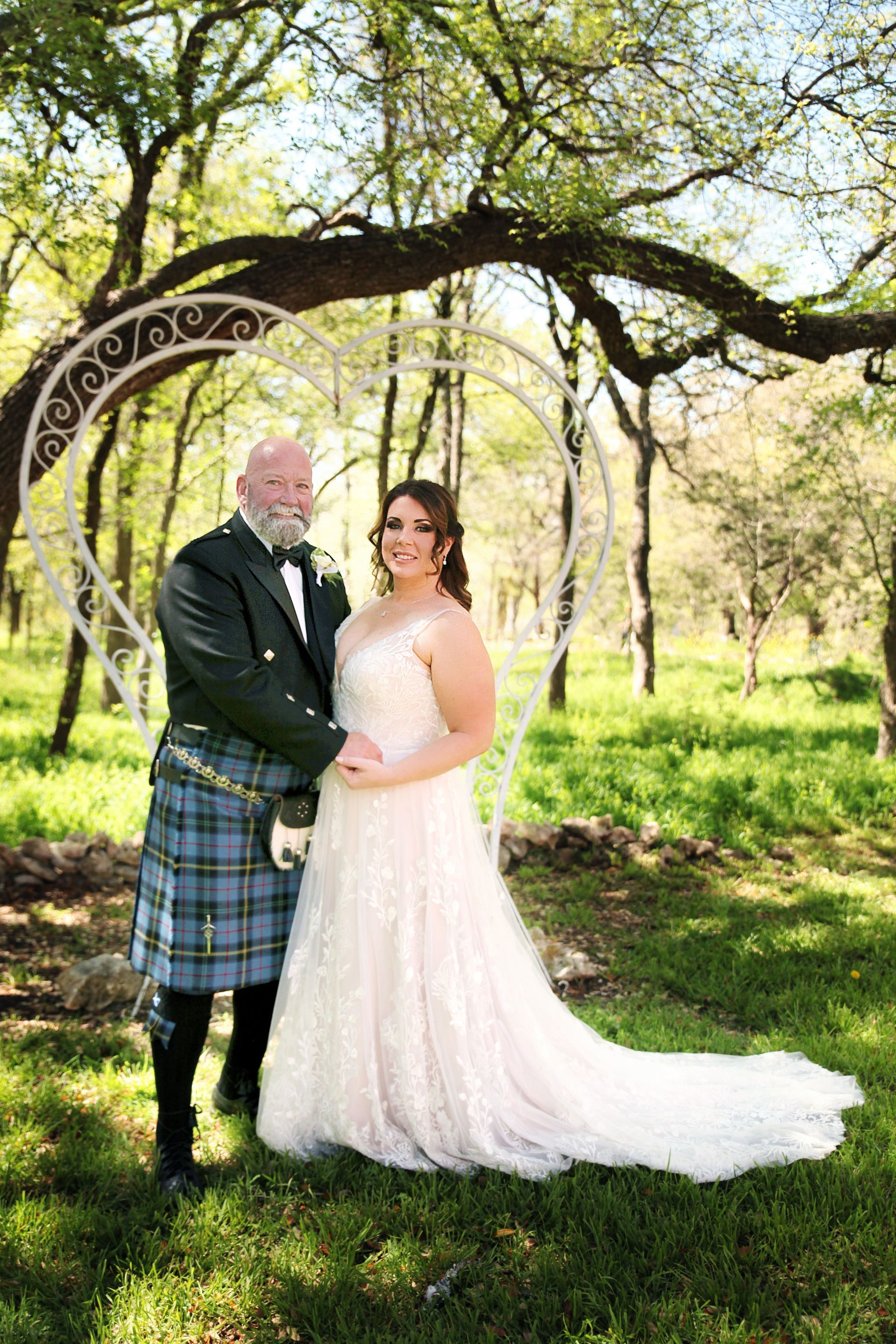 A woman in a wedding dress is standing in front of a window.