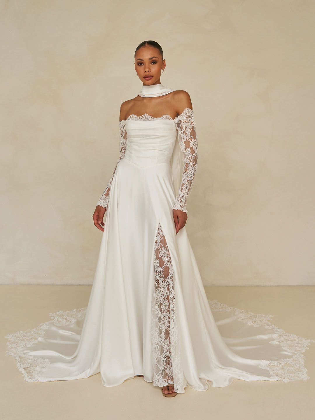 A woman in a white wedding dress is standing in a room with arches.