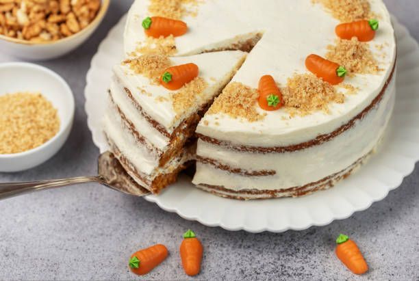 A carrot cake with a slice taken out of it on a plate.