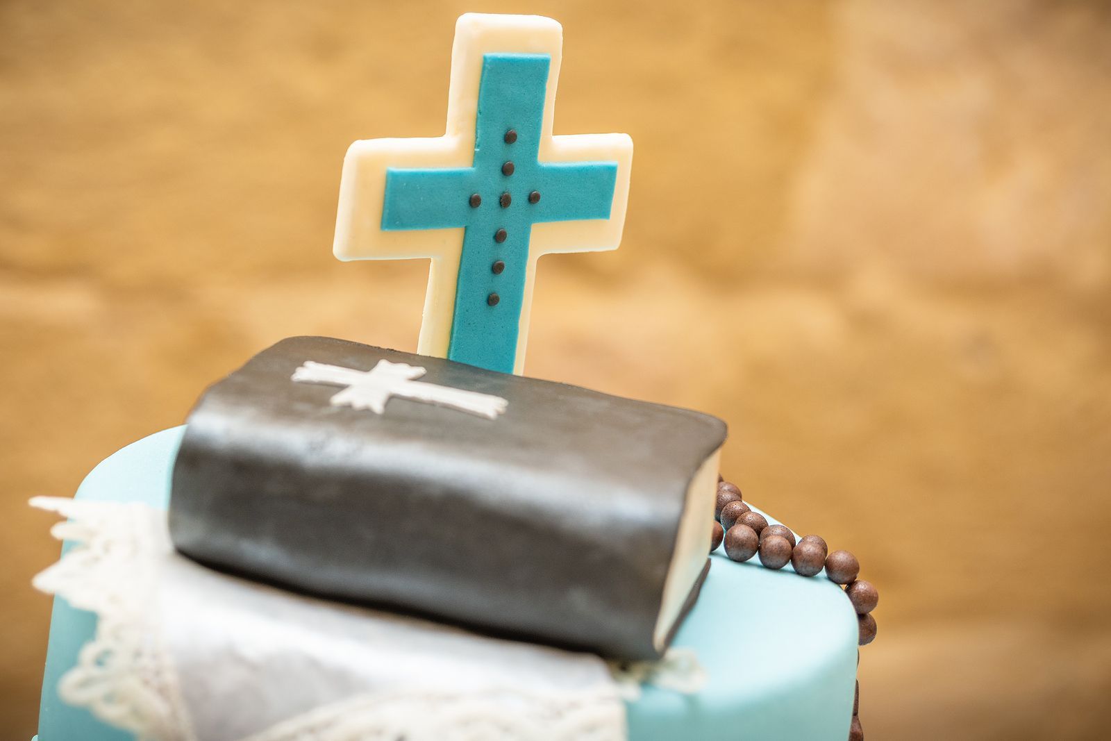 A cake with a cross and a bible on top of it.