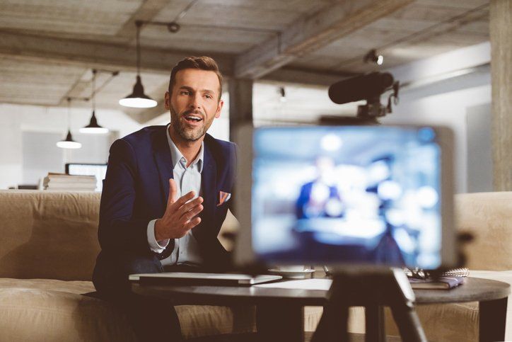 A business man talking to a camera during a webinar