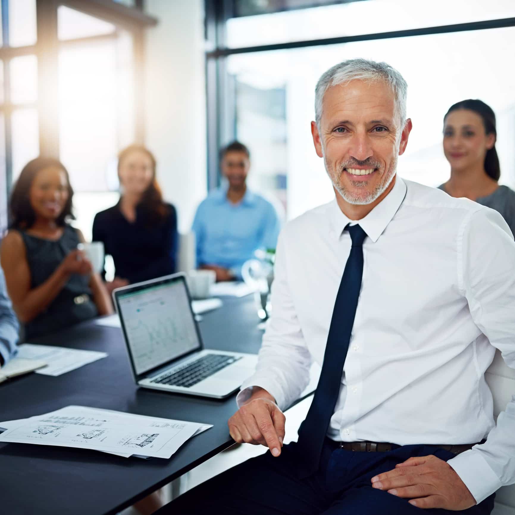 A close up of a man seated at a table during a business meeting