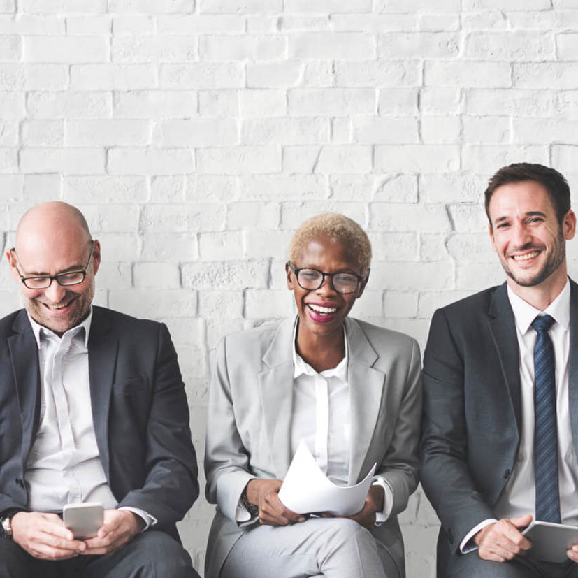 Three business people sitting and laughing together