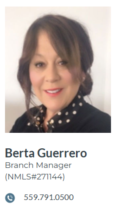 Berta Guerrero, branch manager, smiling, wearing a black coat with a white-dotted scarf.