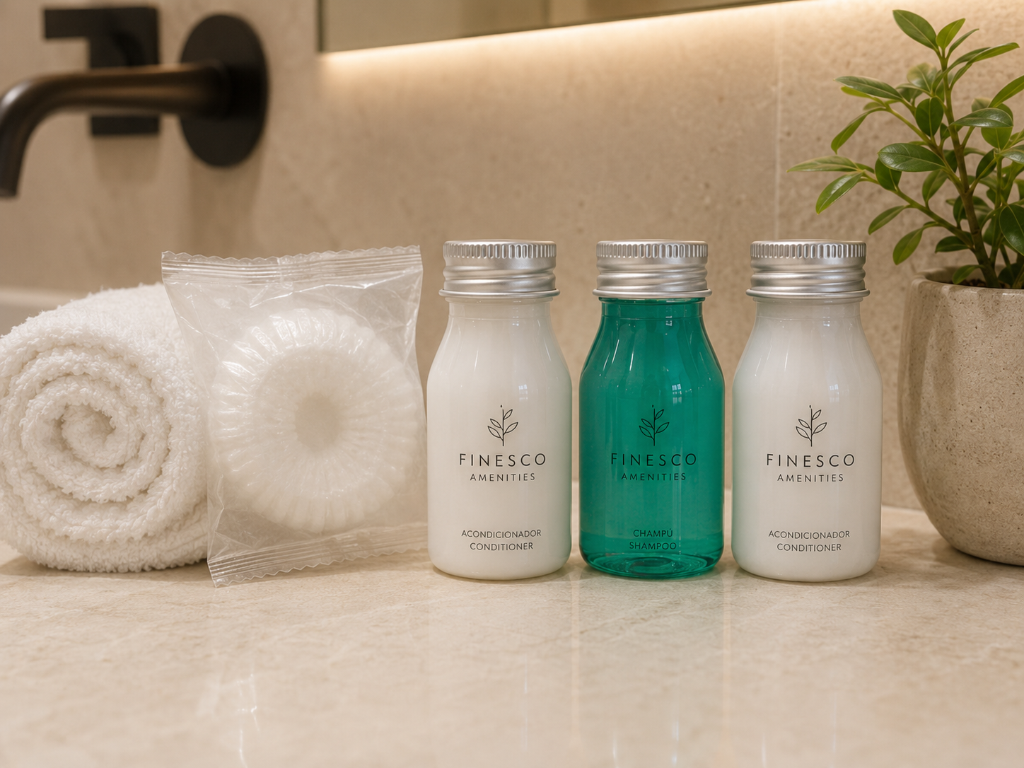 Toallas, productos de baño y una planta en maceta sobre una encimera de baño de color beige.