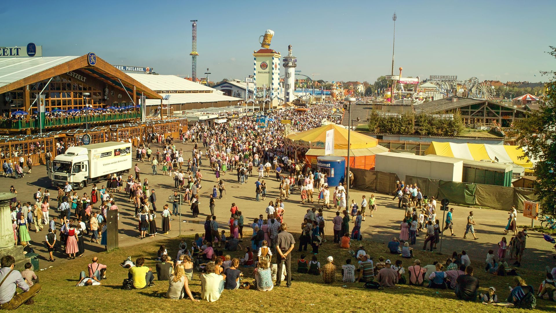 Große Menschenmenge beim Oktoberfest in München, Deutschland, mit Zelten, Bier und Menschen in Tracht.