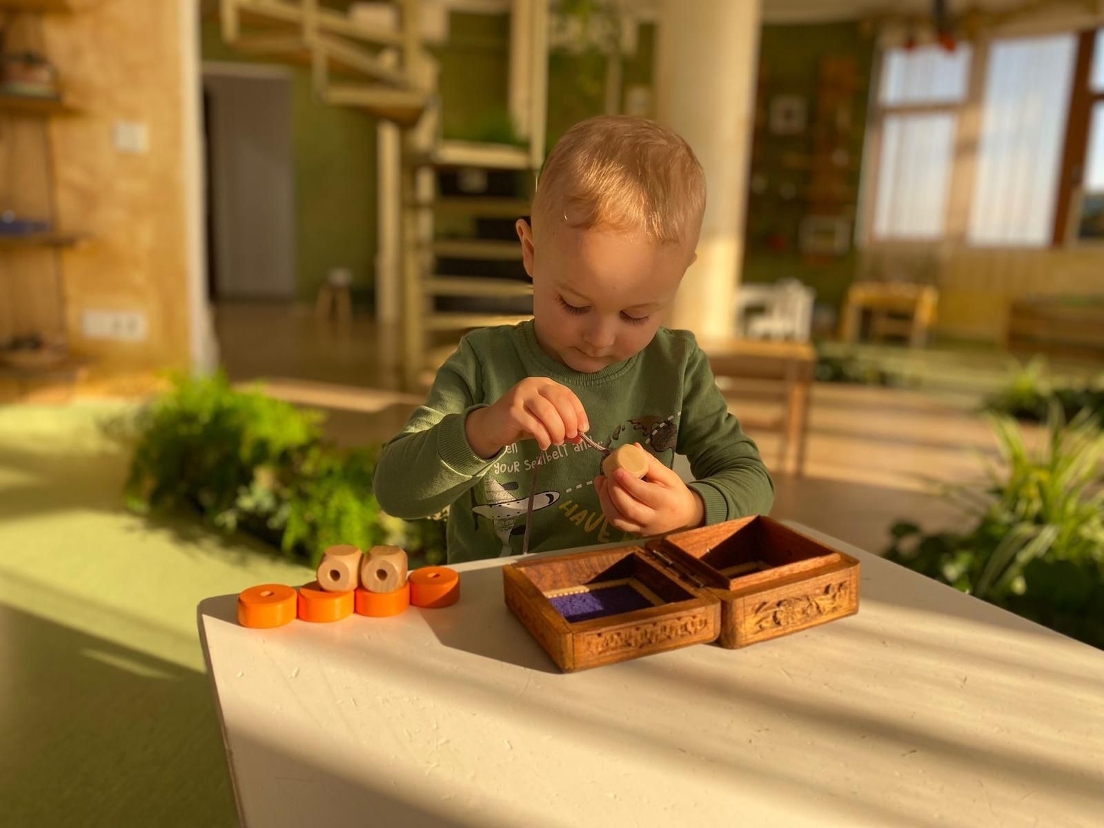 Un baiat lucrand cu Materiale 0-3 ani Montessori Cluj la Cresa Montessori Cluj