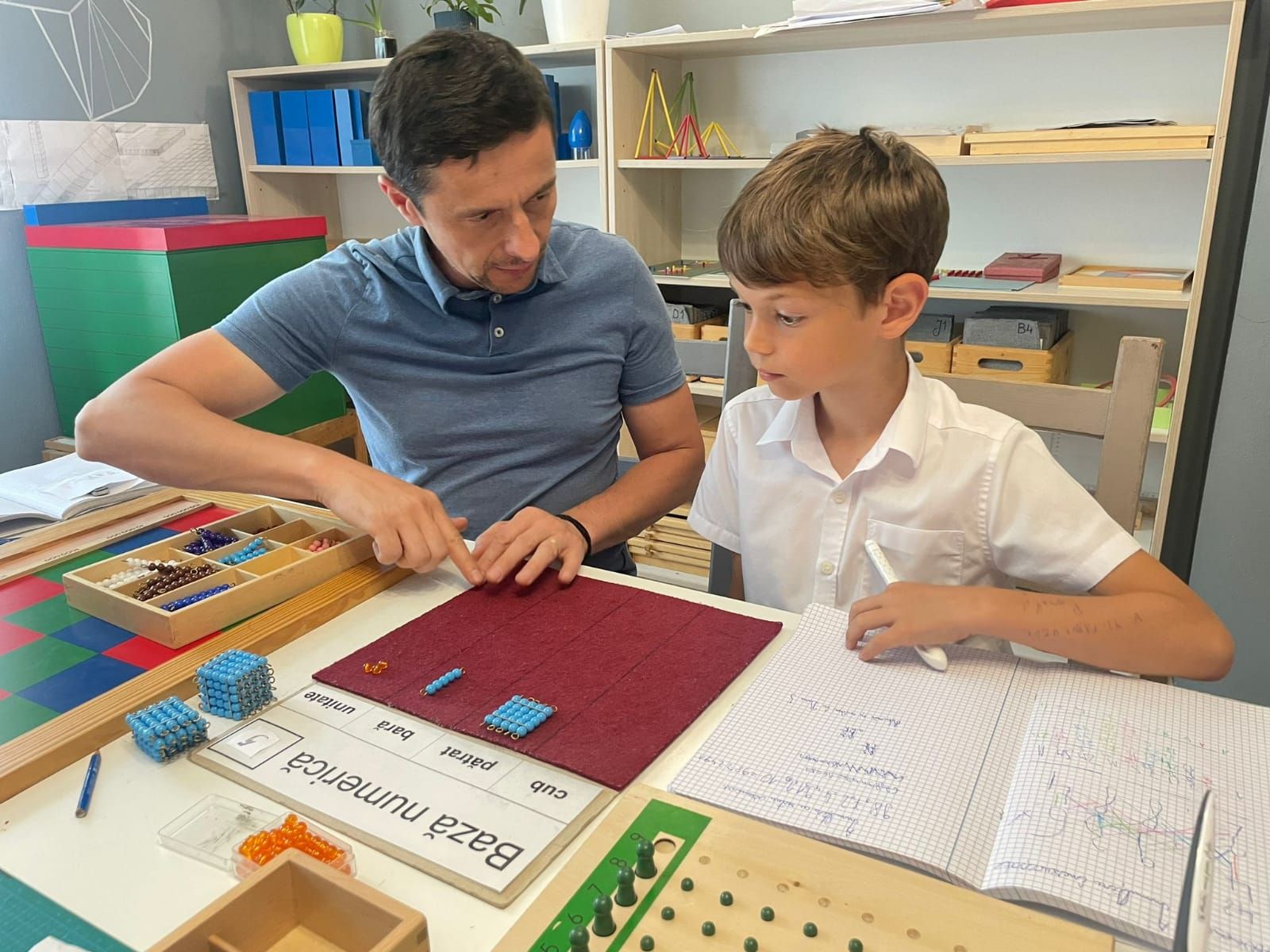 A man and a boy are sitting at a table playing a game.