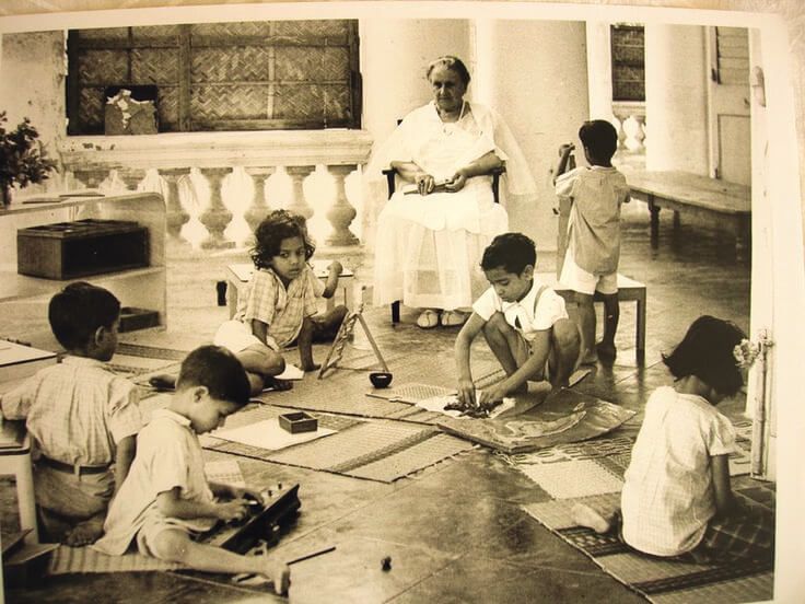Maria Montessori lucrand cu un grup de copii