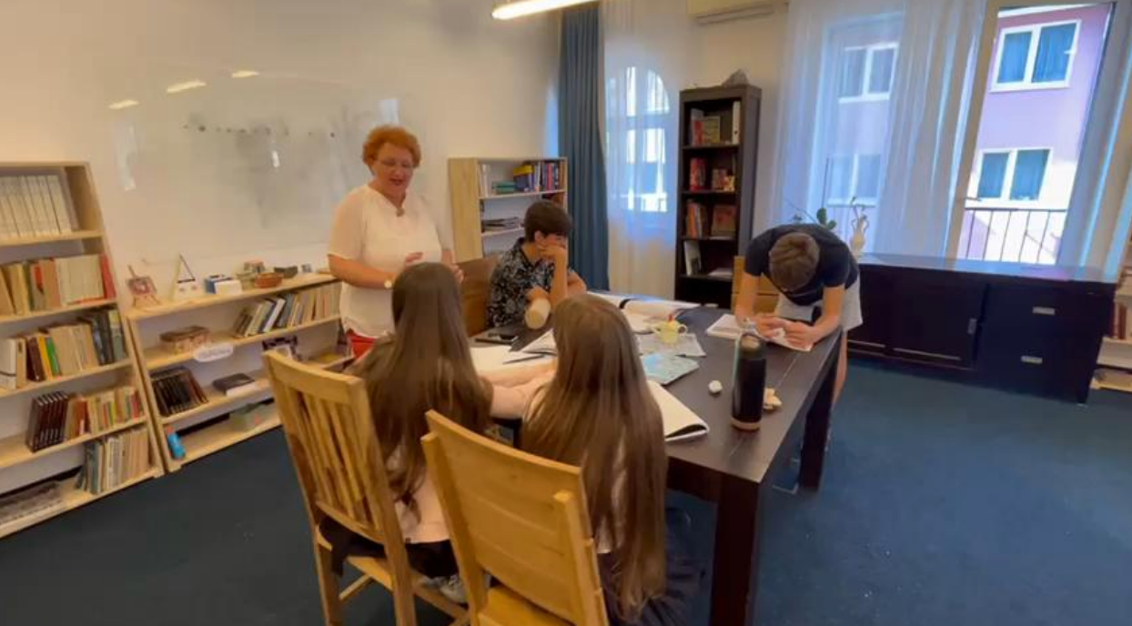 A group of people are sitting around a table in a library.