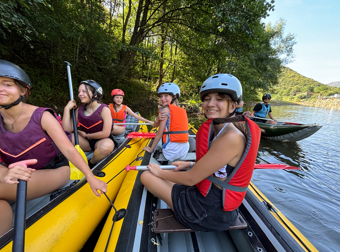 A group of people are sitting in a raft on a river.